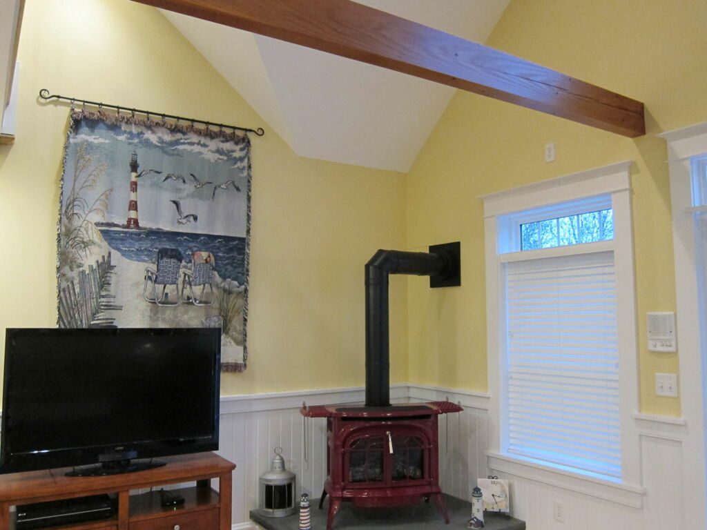 Interior corner with built-in cabinet and wood fireplace trim, walls, and cathedral ceiling painted by IAP Inc. for Merlino Builder in Mashpee, MA.