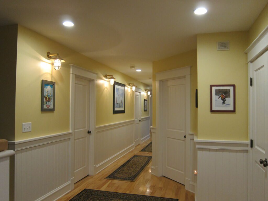 Yellow hallway interior with white trim and doors painted by IAP Inc. for Merlino Builders in Mashpee MA.